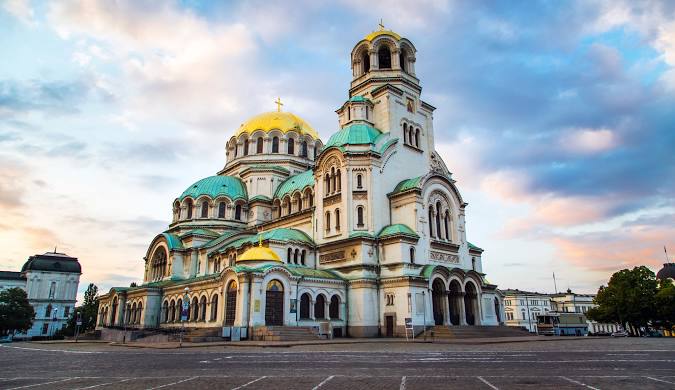 "Alexander Nevsky Cathedral in Sofia, Bulgaria, a grand Neo-Byzantine landmark with gold and green domes, built in 1912 to honor Russian soldiers. It is one of the largest Orthodox cathedrals in the Balkans, known for its stunning architecture and rich interior."